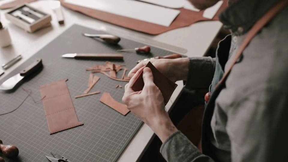 Craftsman working leather on bench